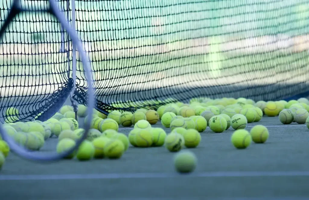 Tennis balls resting on Nova Sports tennis surfaces, highlighting consistent bounce and surface quality.