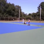 finished outdoor tennis court resurfacing project with blue and green court colors